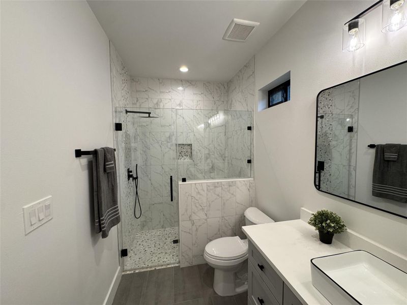 Bathroom with vanity, a marble finish shower, and recessed lighting Bathroom with vanity, a marble finish shower, and recessed lighting