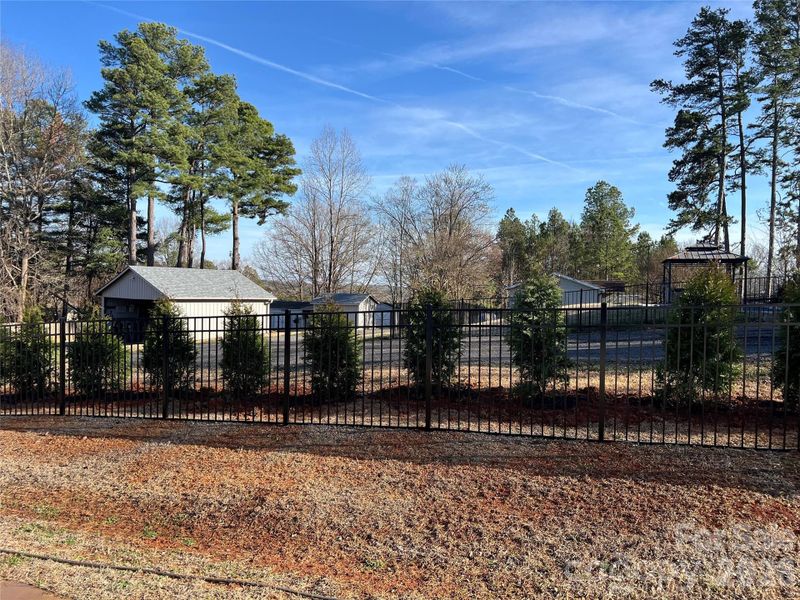 The black aluminum fence and evergreen trees are new additions to this beautiful home. These two additions complete the private backyard space.