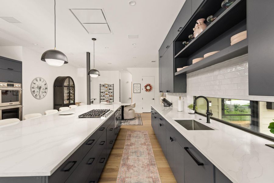 Modern kitchen with crisp white countertops and natural wood flooring offers a sleek culinary experience. Modern kitchen with crisp white countertops and natural wood flooring offers a sleek culinary experience.