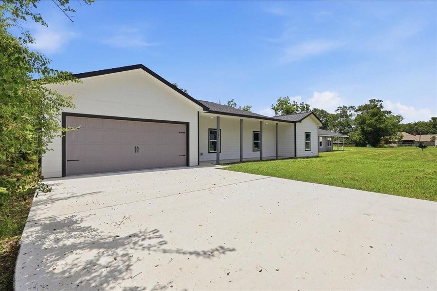 A wide concrete driveway leads up to the spacious two-car garage, offering plenty of parking space. A wide concrete driveway leads up to the spacious two-car garage, offering plenty of parking space.