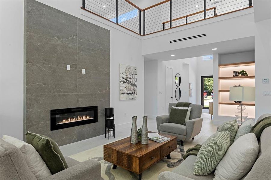 Living room with a towering ceiling and a tile fireplace