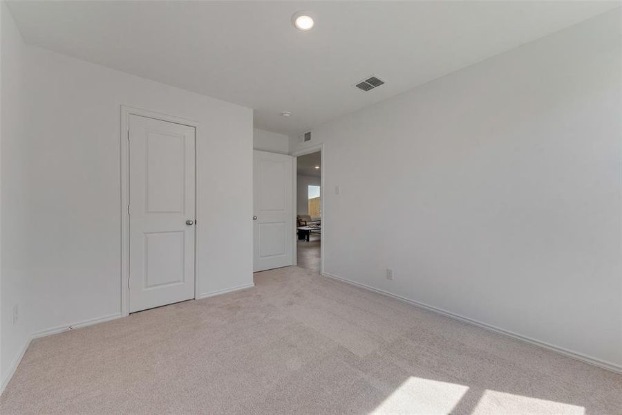 Unfurnished bedroom featuring light colored carpet