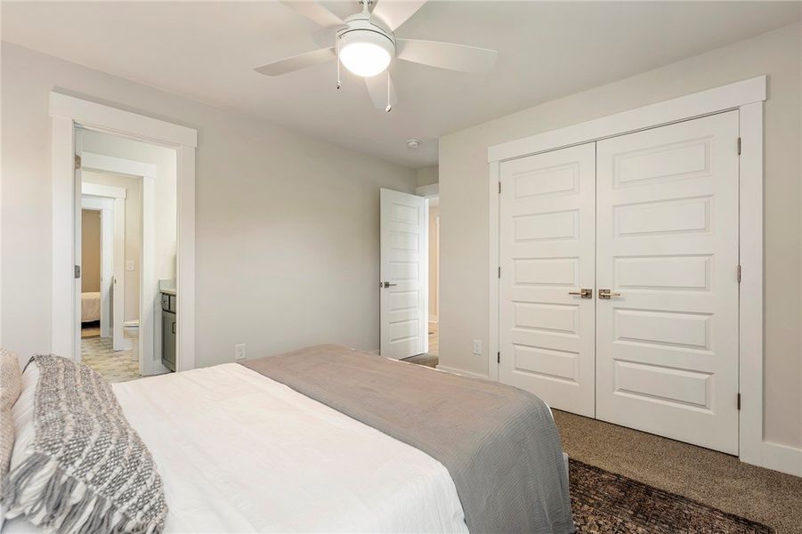 This restful bedroom features a ceiling fan, plush This restful bedroom features a ceiling fan, plush