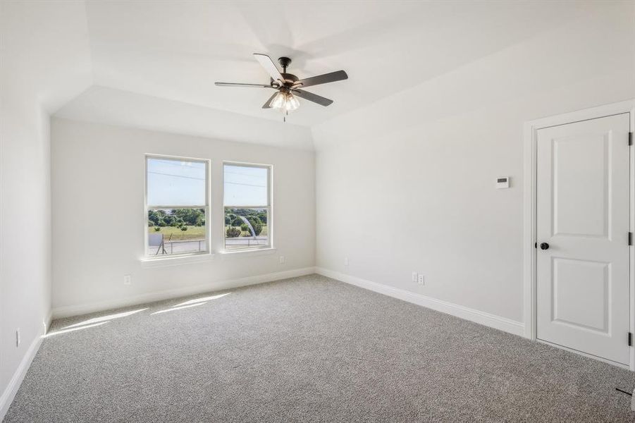 Carpeted spare room with ceiling fan