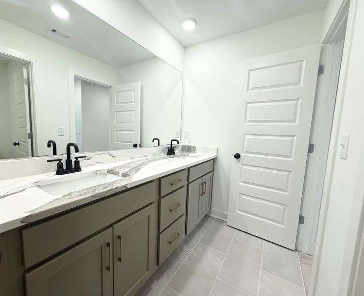 Bathroom with double vanity, recessed lighting, and light tile patterned floors
