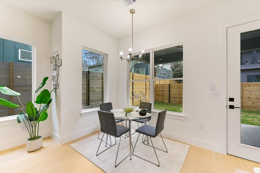 The dedicated dining nook is surrounded by oversized windows, bringing the "outdoor-in" feel that defines Austin living. It’s an intimate spot for dinner parties, overlooking the private fenced yard, a rare and valuable find in the urban core.