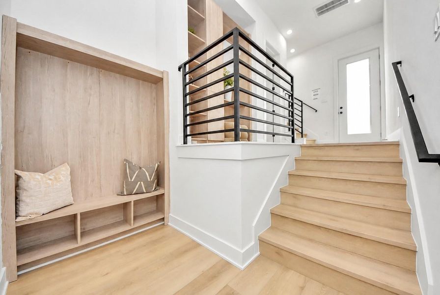 Stylish stair landing featuring sleek black railings and custom built-in storage.