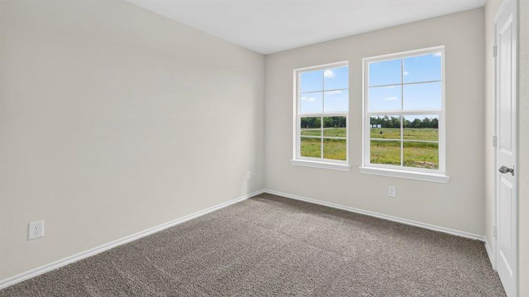 Room featuring two large windows with grid muntins, light gray wall paint, white baseboards, and gray carpeting