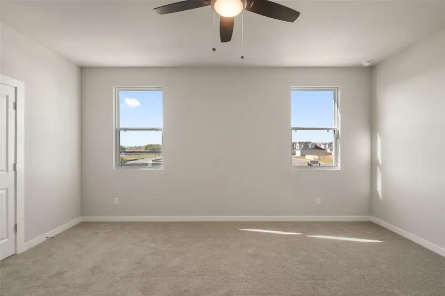 Empty room featuring light colored carpet and a ceiling fan Empty room featuring light colored carpet and a ceiling fan