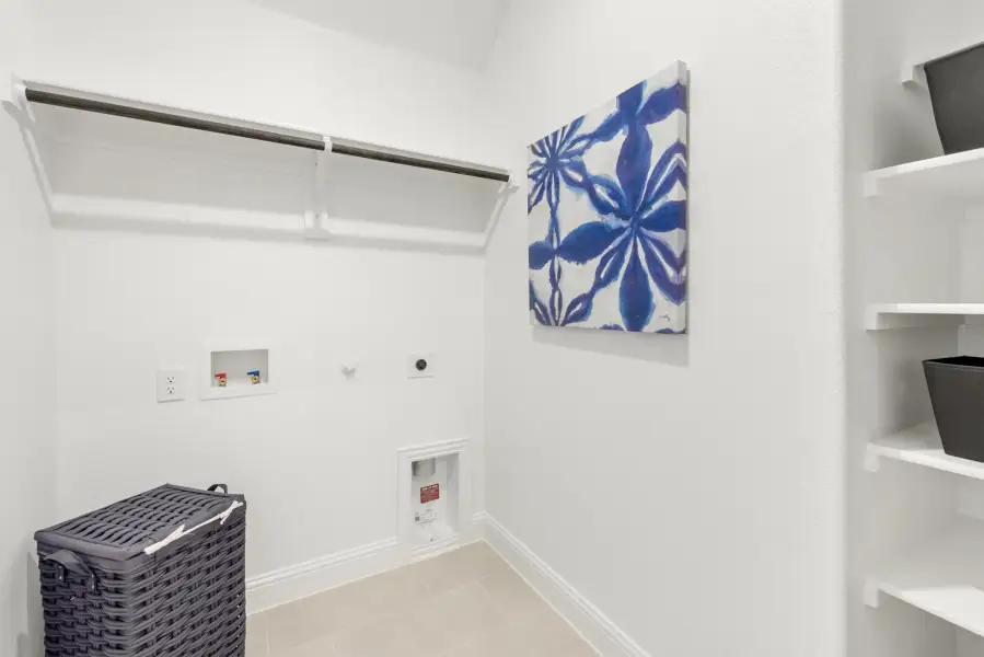 Laundry room with washer and dryer hookups, hanging rod, built-in shelves, and a wicker hamper basket