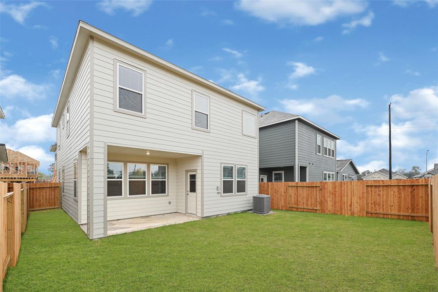 This photo showcases the backyard of a modern two-story home with a clean exterior and ample fenced yard space, perfect for outdoor activities. A covered patio area and well-maintained lawn add to its appeal.Please note: The image is not the actual home; it is a home with the same floor plan in the neighborhood. Finishes may vary. This photo showcases the backyard of a modern two-story home with a clean exterior and ample fenced yard space, perfect for outdoor activities. A covered patio area and well-maintained lawn add to its appeal.Please note: The image is not the actual home; it is a home with the same floor plan in the neighborhood. Finishes may vary.