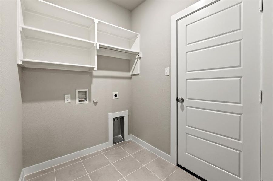 Laundry area with hookup for a washing machine, hookup for a gas dryer, electric dryer hookup, and light tile floors