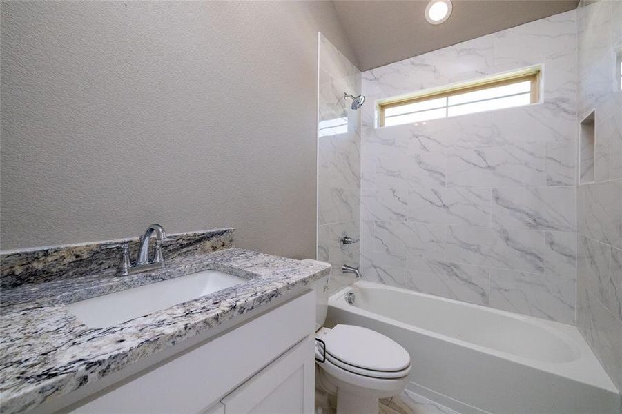 Full bathroom featuring vanity, toilet, and tiled shower / bath