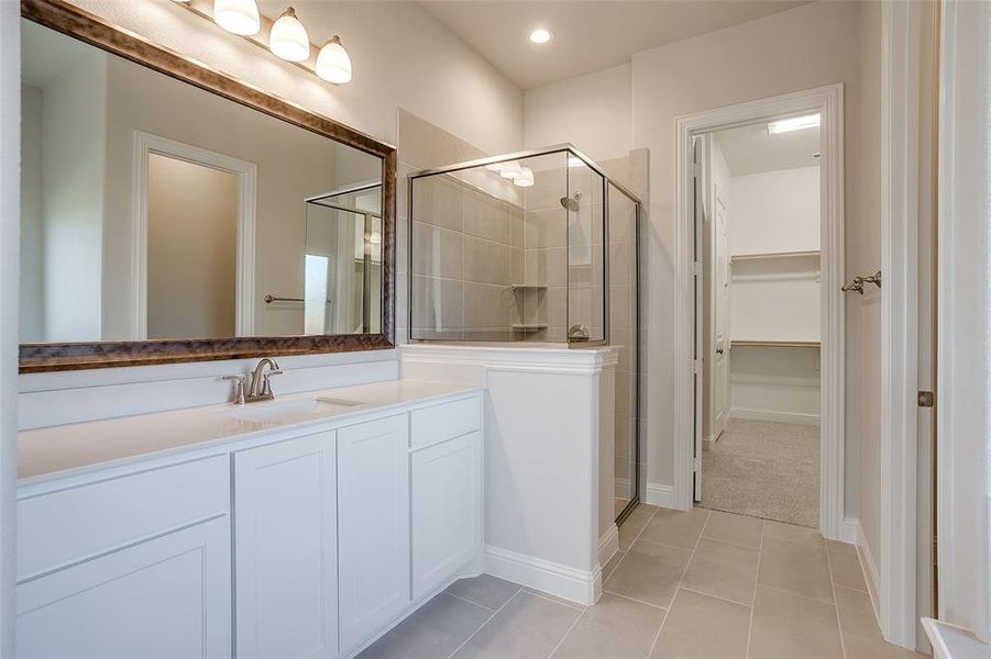 Bathroom with vanity, an enclosed shower, and tile patterned floors