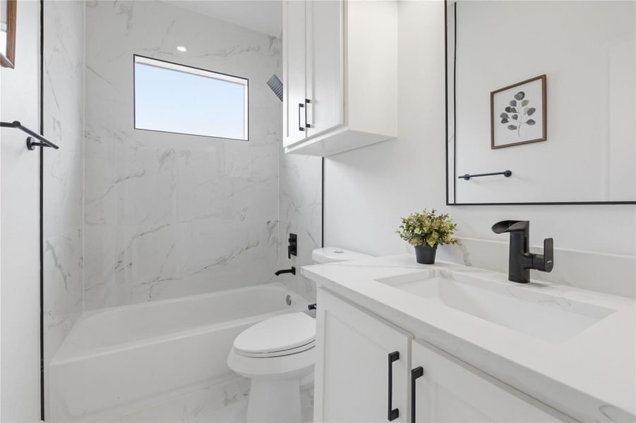 Bathroom featuring vanity, tub / shower combination, and marble look tile flooring