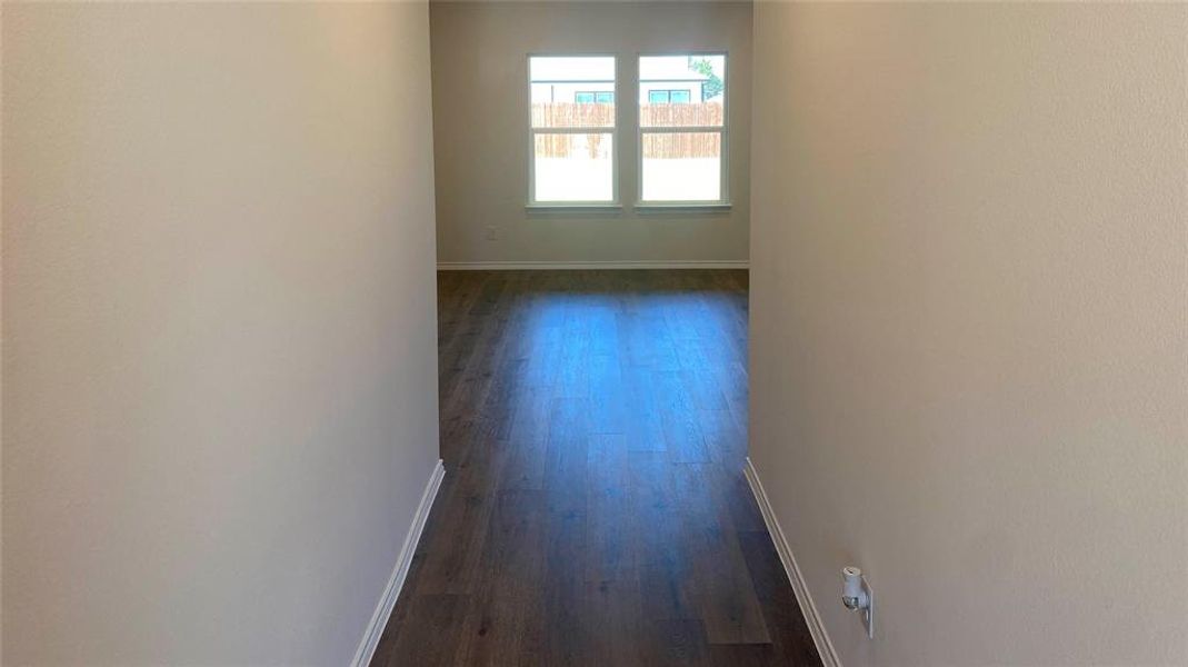 Hallway featuring baseboards and dark wood-style flooring