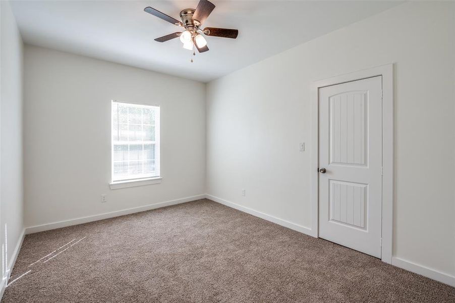 Carpeted empty room with ceiling fan