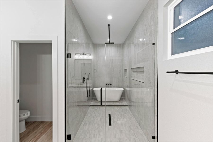 This modern bathroom features a spacious walk-in shower with glass doors, a freestanding tub, and sleek fixtures. The design is elegant with light-colored tiles and a separate toilet area for added privacy. This modern bathroom features a spacious walk-in shower with glass doors, a freestanding tub, and sleek fixtures. The design is elegant with light-colored tiles and a separate toilet area for added privacy.