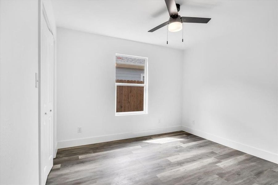 Unfurnished room featuring ceiling fan and dark wood-type flooring