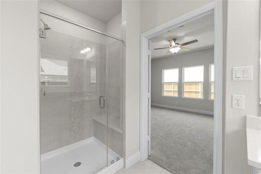 Bathroom featuring walk in shower and ceiling fan