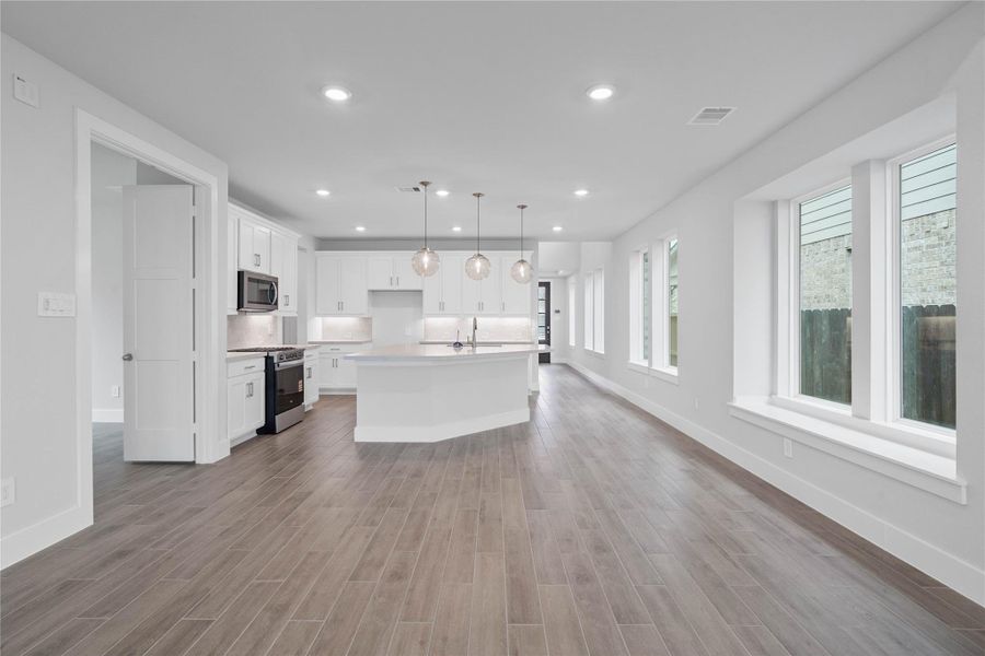 Create lasting memories around the table with family and friends in the dining! It showcases high ceilings, large windows, wood tile flooring, and recessed lighting for a warm and welcoming atmosphere.