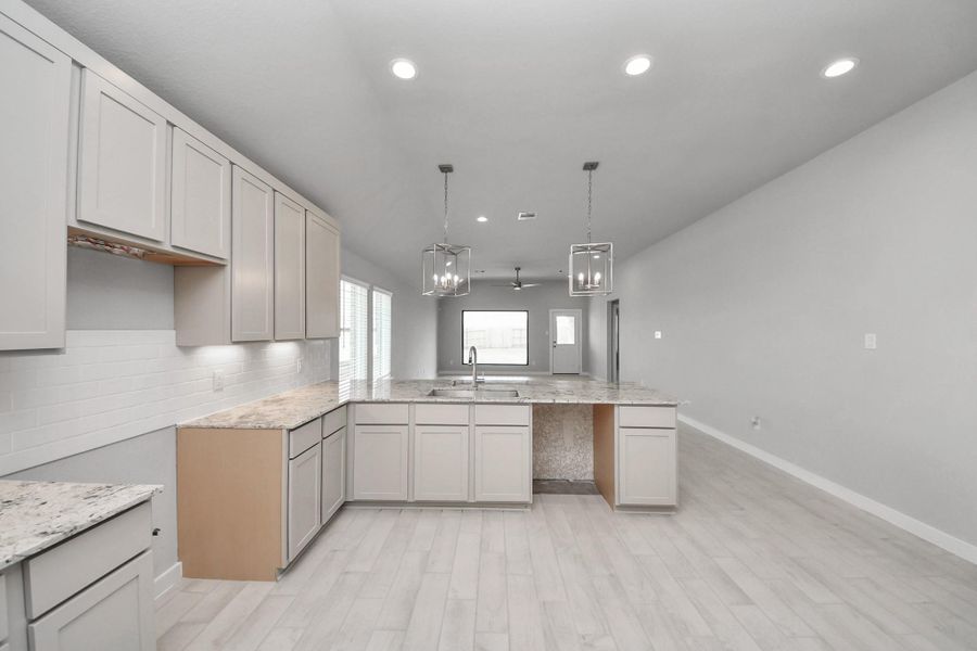 The open concept effortlessly connects the kitchen to the expansive family room, forming a perfect hub for gatherings. This seamless flow creates an inviting space where cooking and socializing come together harmoniously. Sample photo of completed home with similar floor plan. Actual colors and selections may vary.