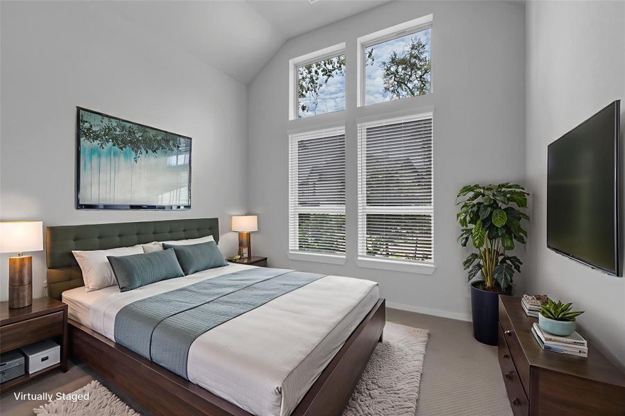 Primary bedroom with large windows and tall ceilings.