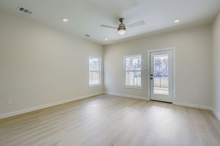 A room with a wood floor and a ceiling fan.