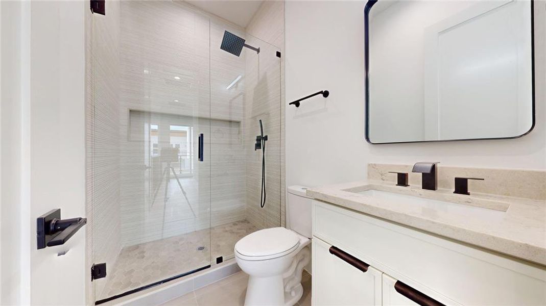 Bathroom featuring a shower stall, vanity, and light tile patterned floors