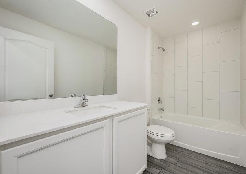 The guest bathroom has a beautifully tiled bathtub