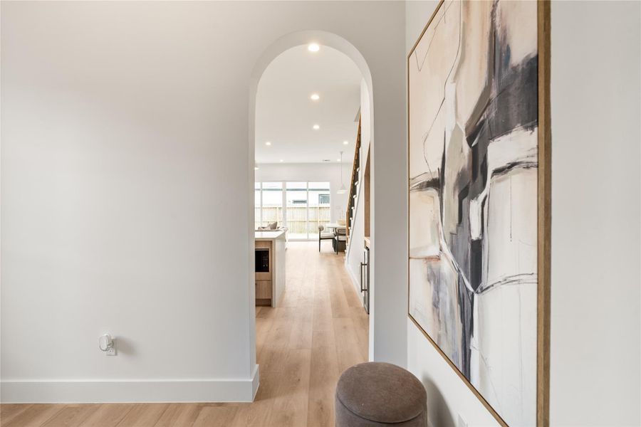 This transitional hallway sets up sightlines straight through to the kitchen, living, and staircase, so the whole first floor reads as one connected space. You feel the flow before you even reach it.
