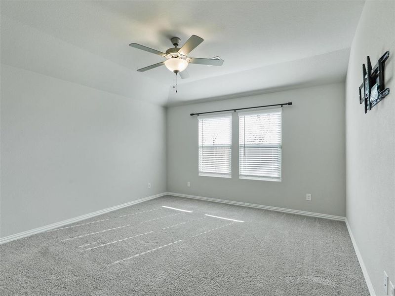 Carpeted empty room with ceiling fan