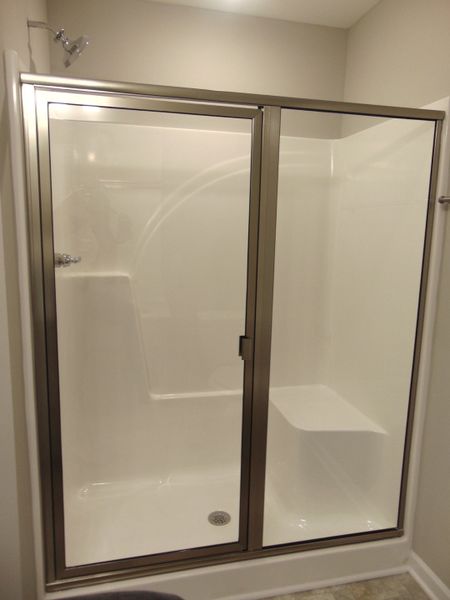 The primary bedroom comes with a modern shower, two sinks, and an elongated toilet, as well as a linen closet