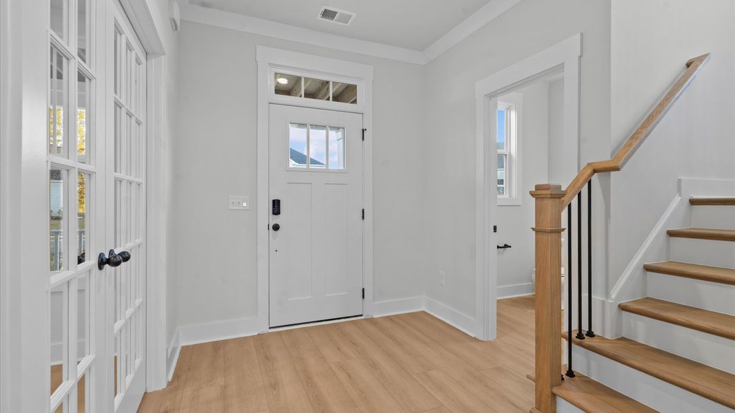 Highly functional foyer with hardwood flooring that flows seamlessly into living spaces