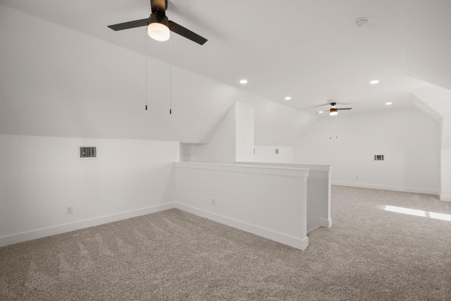 A spacious, naturally illuminated attic offers versatile living space with sloped ceilings and ample room for various arrangements. A spacious, naturally illuminated attic offers versatile living space with sloped ceilings and ample room for various arrangements.