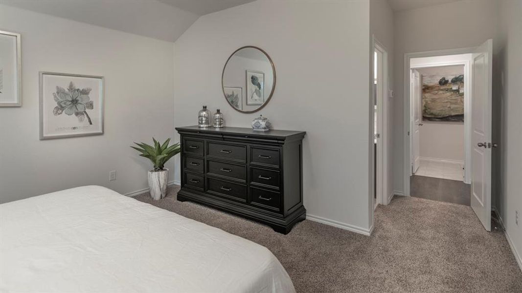 Carpeted bedroom featuring baseboards and lofted ceiling