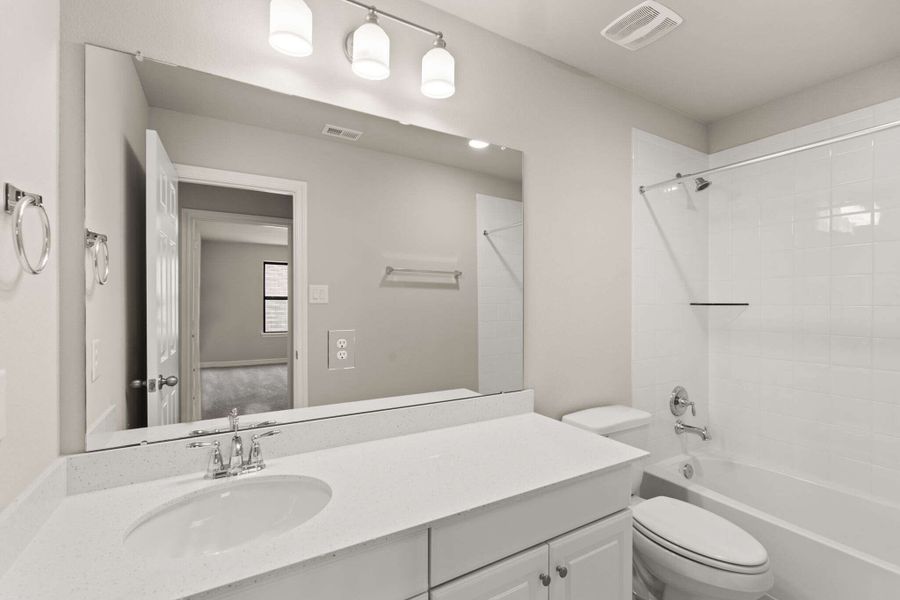 The secondary bath features a double sink vanity and shower/tub combo perfect for accommodating family and friends.