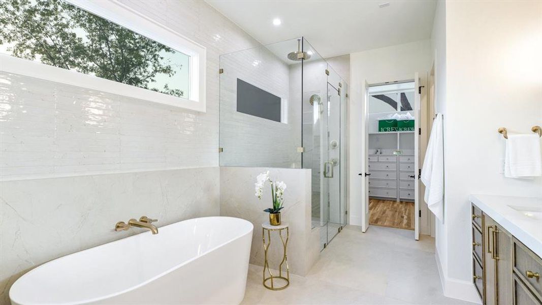 Bathroom with vanity, tile patterned floors, shower with separate bathtub, and tile walls