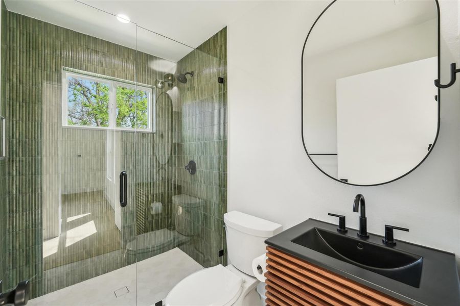Full bathroom with toilet, a shower stall, and vanity