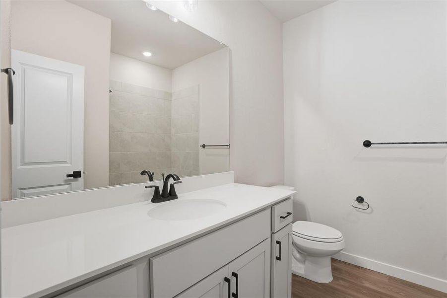 Bathroom with dark wood-style flooring, vanity, recessed lighting, and a shower Bathroom with dark wood-style flooring, vanity, recessed lighting, and a shower
