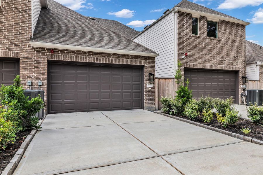 Attached two-car garage with a side gate providing entry to the patio area.