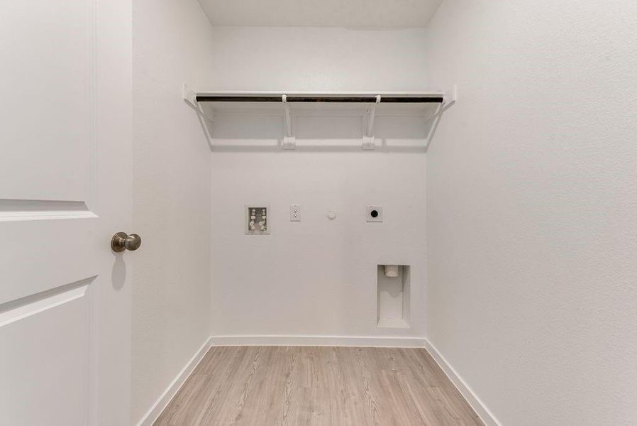 Laundry room with gas dryer hookup, hookup for a washing machine, laundry area, light wood-type flooring, and electric dryer hookup