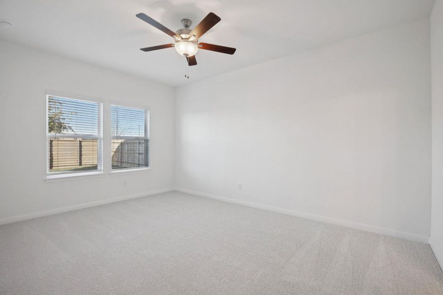 Unfurnished room with light colored carpet and ceiling fan