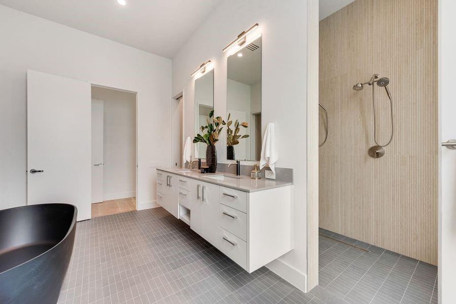 Dual vanities and a walk-in shower create a functional yet refined primary experience.
