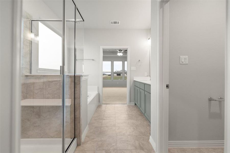 Bathroom with vanity, a garden tub, a shower stall, and ceiling fan Bathroom with vanity, a garden tub, a shower stall, and ceiling fan