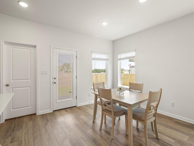 A well-lit dining area featuring warm hardwood floors and ample natural light.