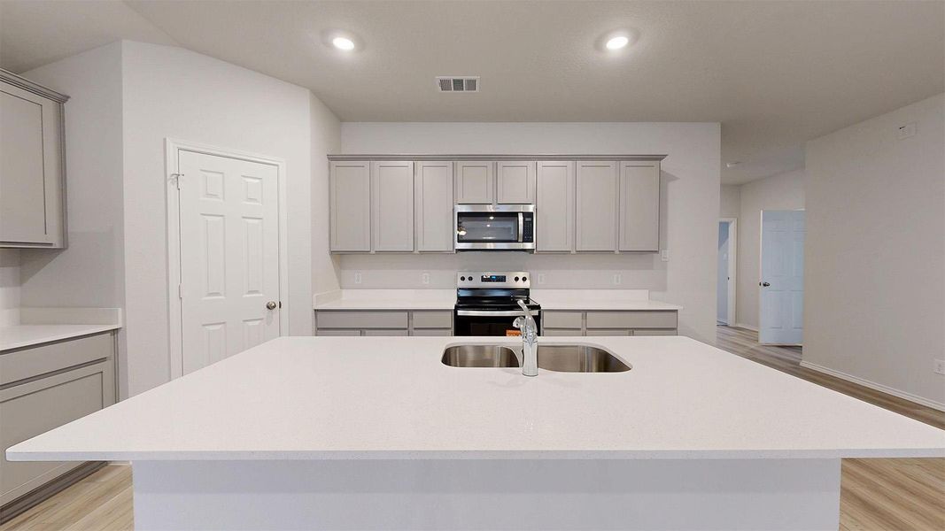 A well-appointed kitchen showcasing an inviting island with a sink and modern appliances.