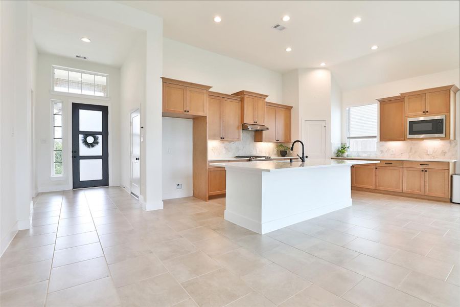 A huge island with a farmhouse sink seamlessly connects to the living area, offering the perfect space for entertaining. Enjoy plenty of cabinet storage to keep everything organized and within reach! A huge island with a farmhouse sink seamlessly connects to the living area, offering the perfect space for entertaining. Enjoy plenty of cabinet storage to keep everything organized and within reach!