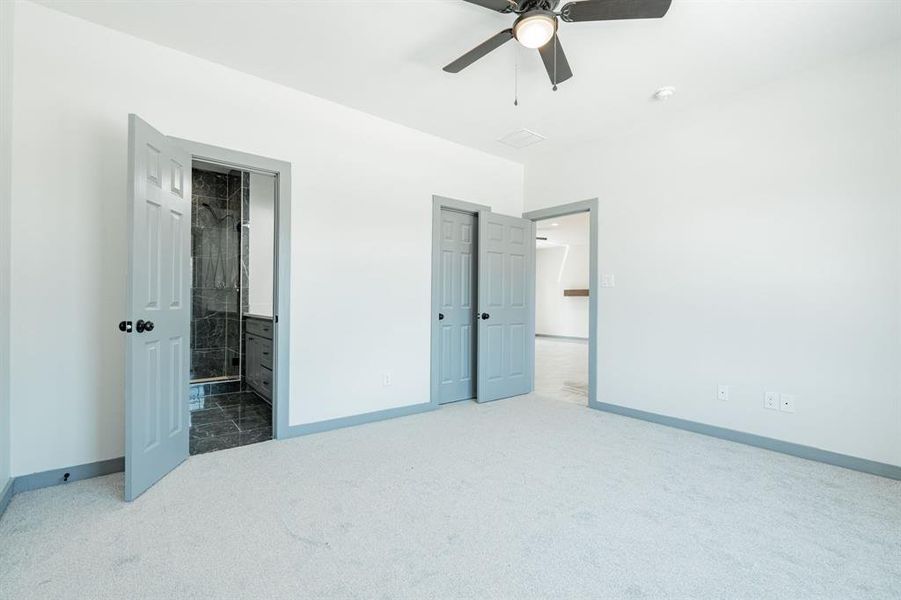 Bedroom with ceiling fan, carpet, and ensuite bathroom