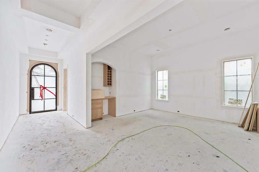 Another view of the formal dining room which features a dry bar, perfect for entertaining! View of the beautiful arched steel front door.